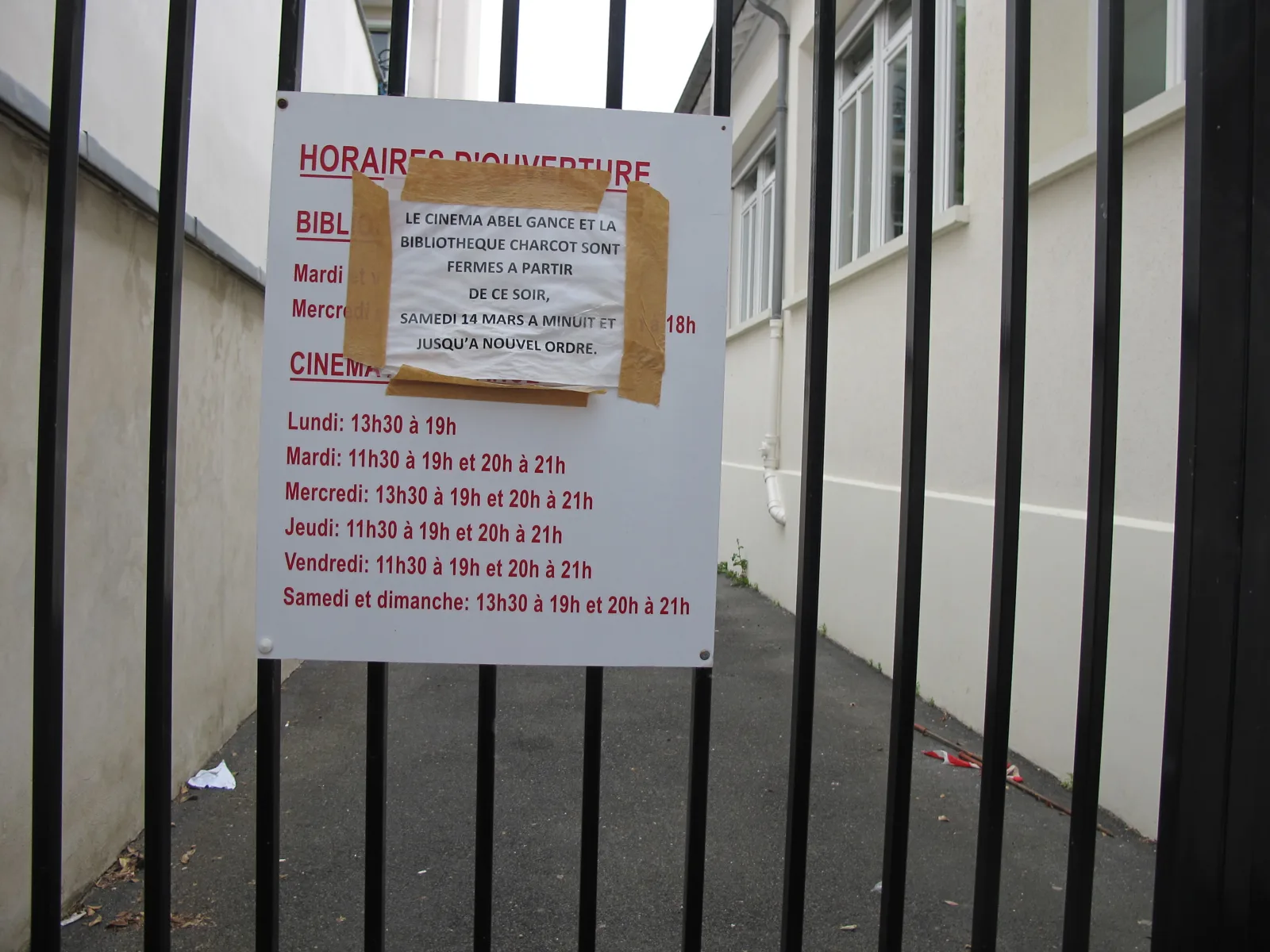 An archived closure notice is taped over the opening-hours board at Bibliothèque Charcot in Courbevoie.