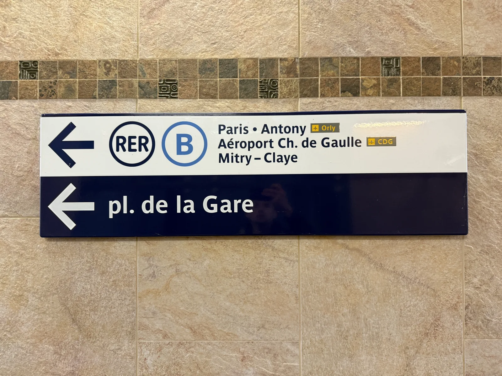 Station signs point left towards RER B platforms and place de la Gare.