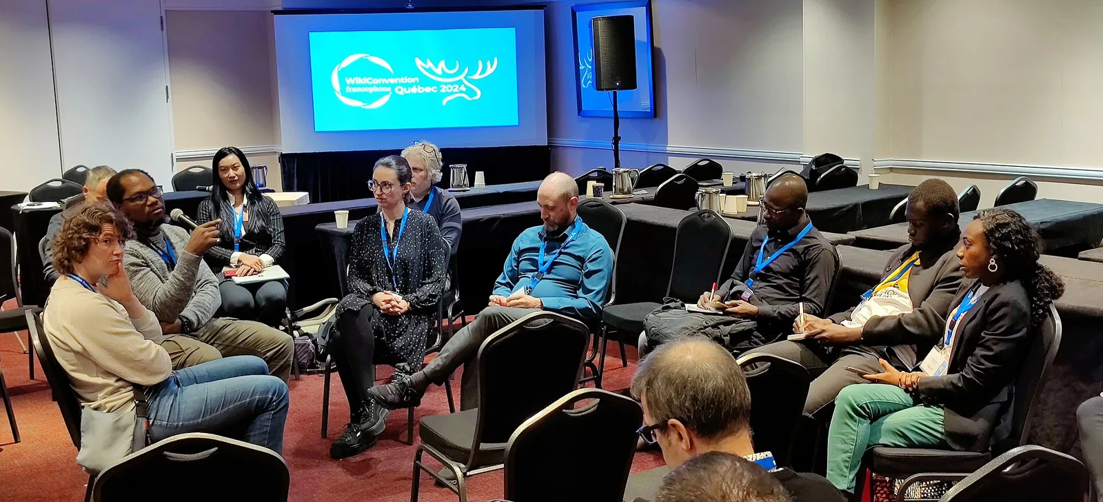 Workshop participants seated in a discussion circle at WikiConvention francophone 2024.